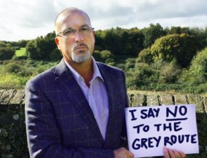 Cllr Steve McAuliffe holds sign reading "I Say No To the Grey Route"